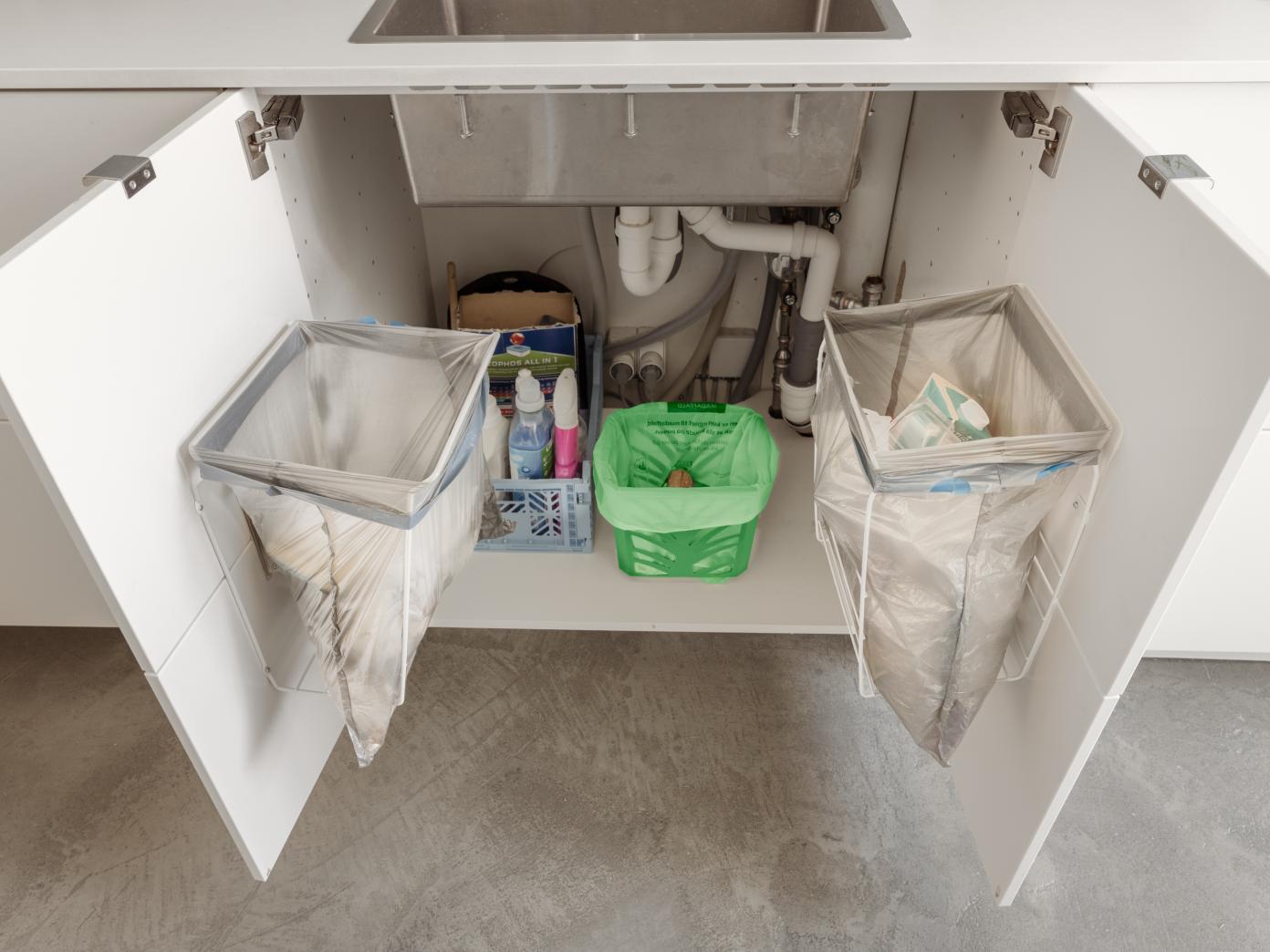 80 centimeter bredt skab med to låger under køkkenvask. På hver låge er fastgjort stativ med affaldspose til restaffald og plastaffald. I bunden af skabet under vasken står køkkenkurv til madaffald.